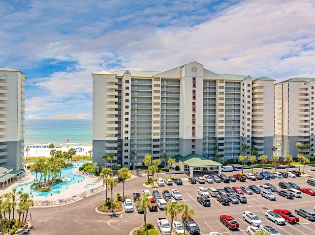 view of property with uncovered parking and a water view