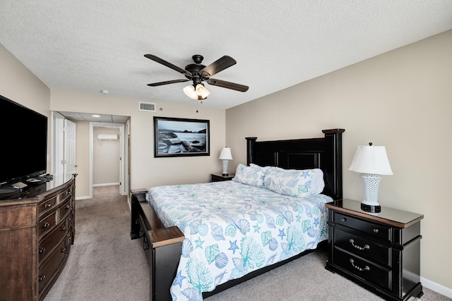 bedroom featuring a textured ceiling, ceiling fan, light colored carpet, visible vents, and baseboards