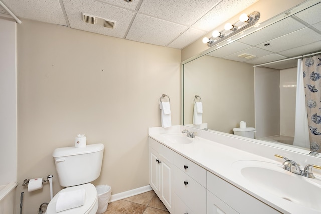 full bath with visible vents, a drop ceiling, a sink, and tile patterned floors