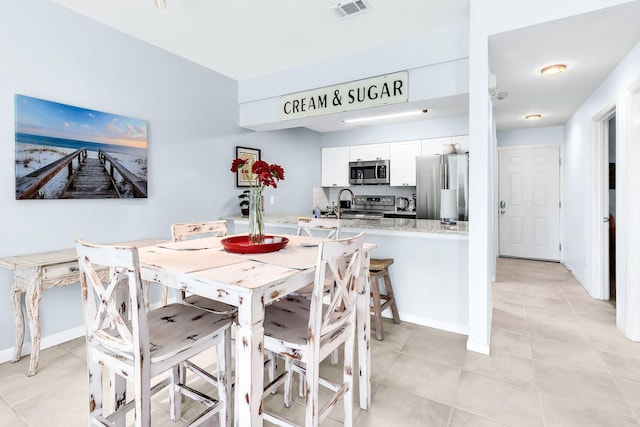 dining area featuring light tile patterned flooring and sink