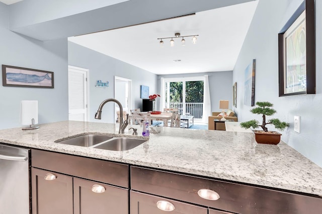 kitchen with sink, light stone countertops, and dishwasher