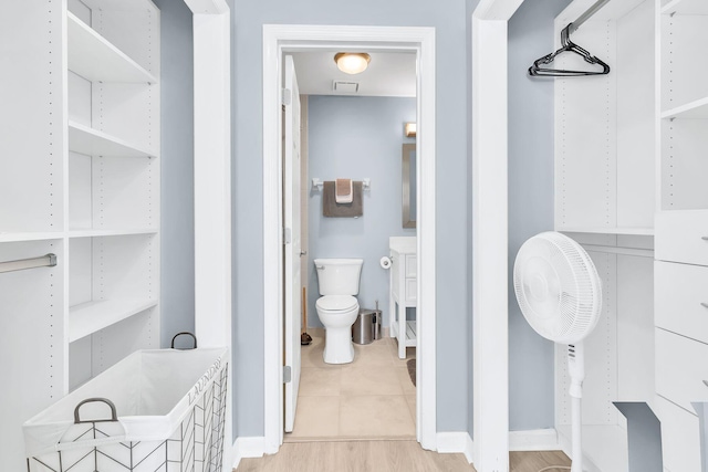 bathroom with toilet and hardwood / wood-style floors