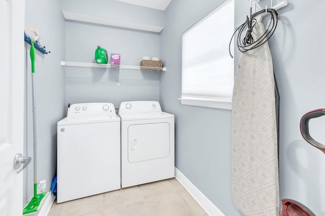 laundry room with independent washer and dryer and light tile patterned floors