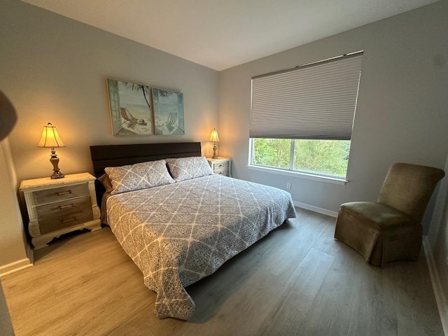 bedroom with hardwood / wood-style flooring and lofted ceiling