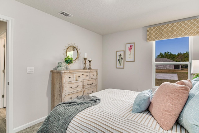 bedroom with a textured ceiling and carpet floors