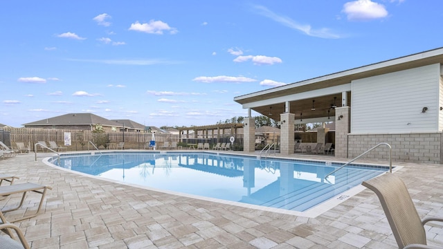 view of swimming pool with ceiling fan and a patio