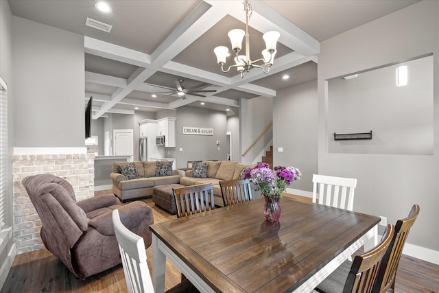 dining space with coffered ceiling, ceiling fan with notable chandelier, dark hardwood / wood-style flooring, and beamed ceiling