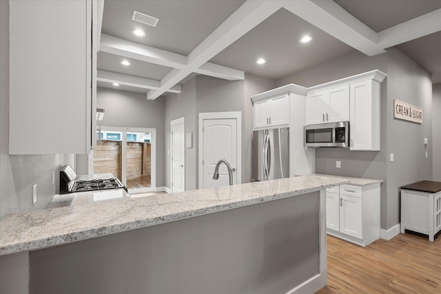 kitchen featuring coffered ceiling, beamed ceiling, light hardwood / wood-style flooring, stainless steel appliances, and white cabinets