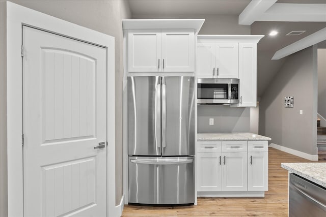 kitchen featuring light stone counters, stainless steel appliances, light hardwood / wood-style floors, and white cabinetry