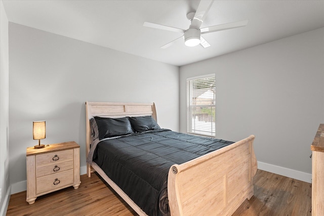 bedroom with dark wood-style floors, ceiling fan, and baseboards