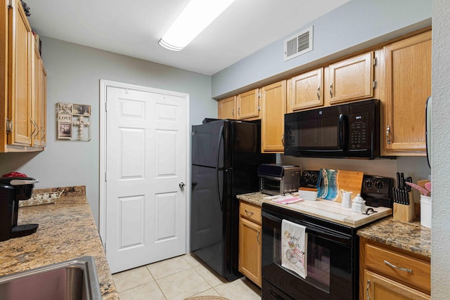 kitchen featuring light tile patterned flooring, stone countertops, sink, and black appliances