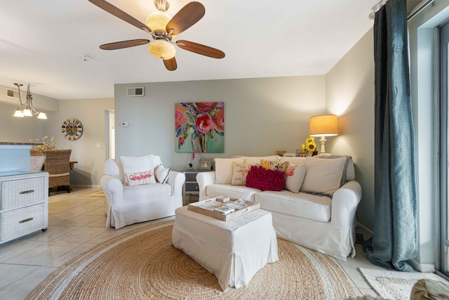 living room featuring ceiling fan with notable chandelier and light tile patterned floors