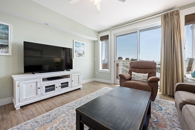 living room with ceiling fan and light hardwood / wood-style flooring