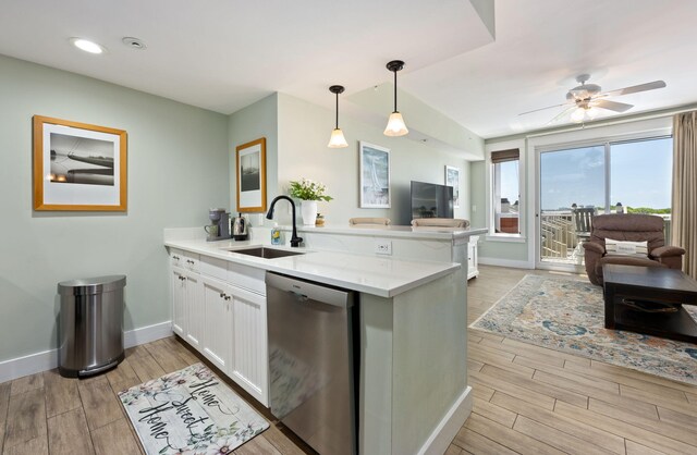 kitchen featuring dishwasher, kitchen peninsula, white cabinetry, and sink