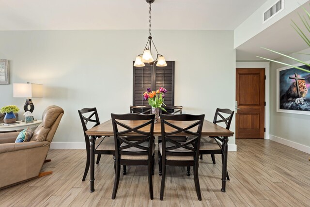 dining area featuring light hardwood / wood-style flooring and a notable chandelier