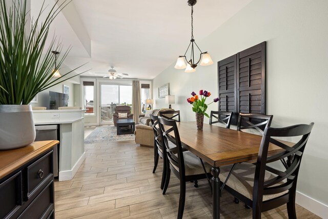 dining room featuring ceiling fan with notable chandelier and light hardwood / wood-style flooring