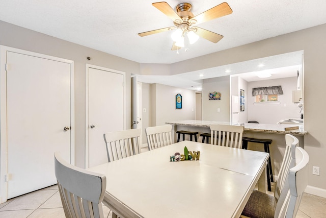 tiled dining space with ceiling fan