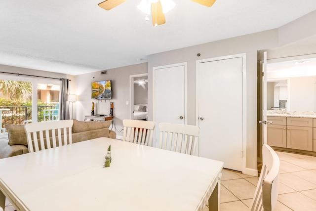 tiled dining space with ceiling fan