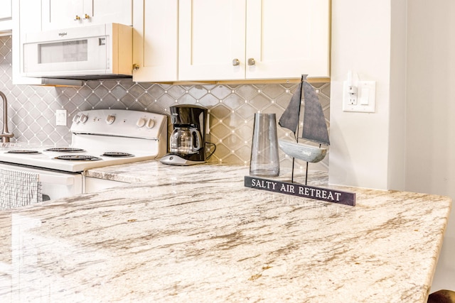 kitchen with tasteful backsplash, white appliances, light stone counters, and white cabinets