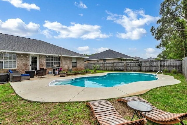 view of pool featuring a lawn and a patio