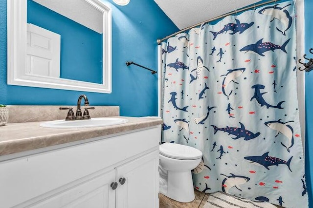 bathroom featuring curtained shower, vanity, a textured ceiling, toilet, and tile patterned floors