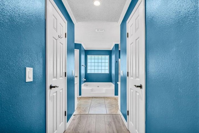 corridor featuring crown molding and light hardwood / wood-style floors