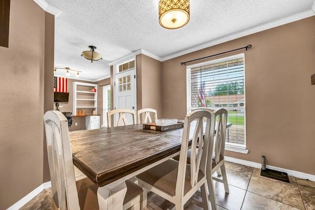 tiled dining area with rail lighting, a textured ceiling, and crown molding