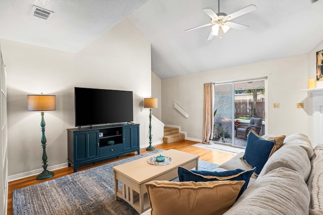 living room featuring ceiling fan, light wood-type flooring, a textured ceiling, and high vaulted ceiling