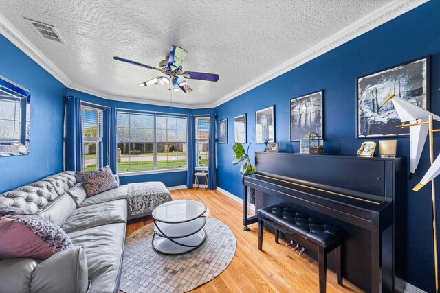 living room featuring ceiling fan, light hardwood / wood-style floors, and ornamental molding