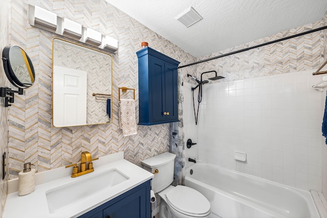 full bathroom featuring tiled shower / bath, toilet, a textured ceiling, and vanity