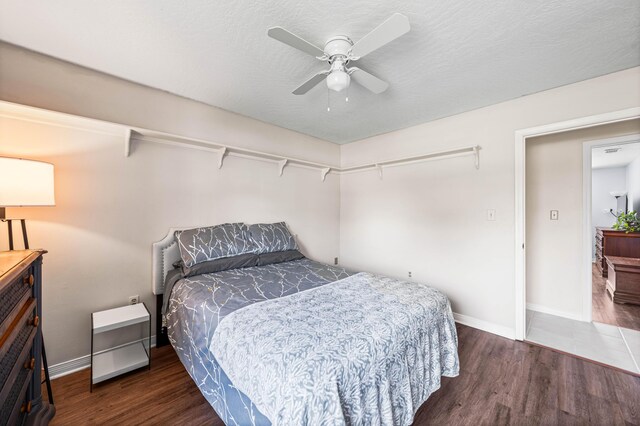 bedroom with dark hardwood / wood-style flooring and ceiling fan