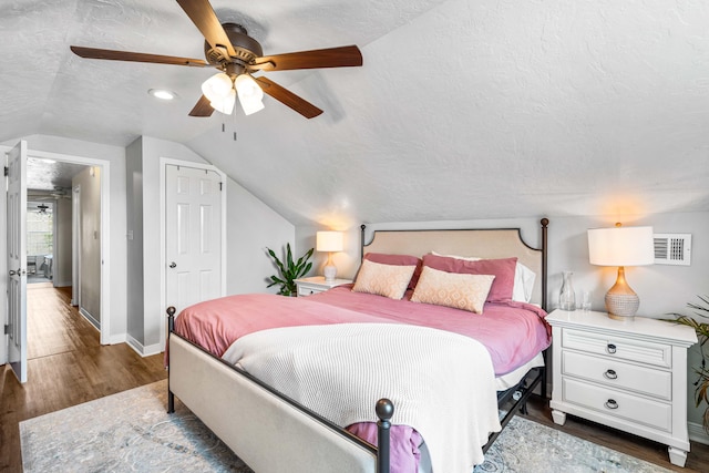 bedroom with a textured ceiling, ceiling fan, lofted ceiling, and dark hardwood / wood-style floors