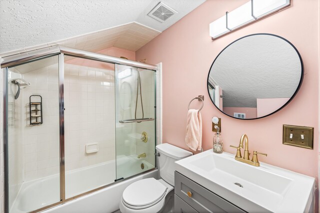 full bathroom featuring toilet, a textured ceiling, vanity, and enclosed tub / shower combo