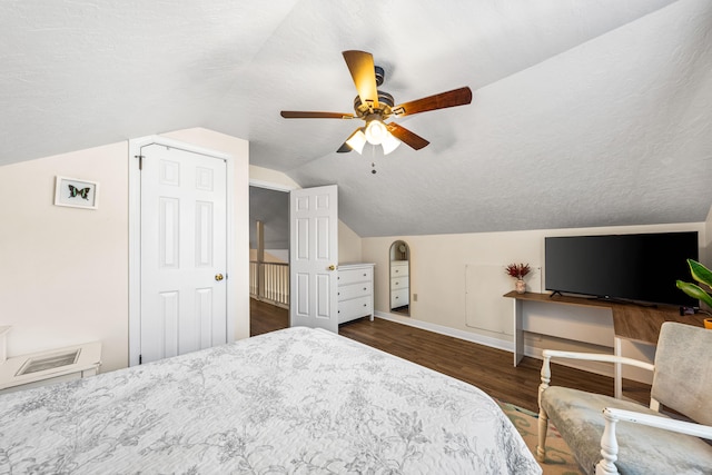 bedroom featuring ceiling fan, a textured ceiling, lofted ceiling, and dark wood-type flooring