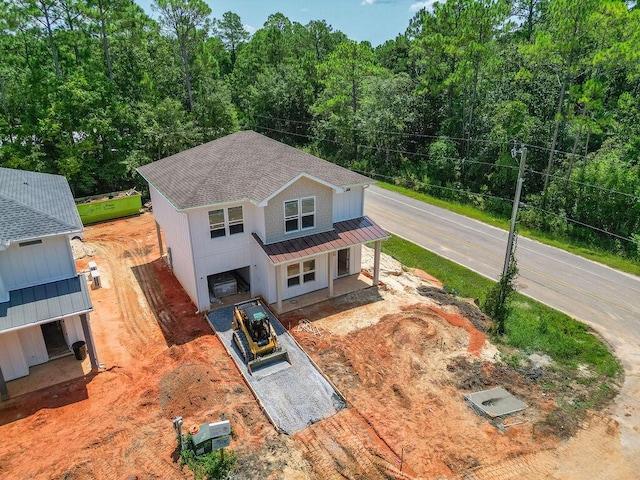 view of front of home with a shingled roof, a standing seam roof, metal roof, and a porch