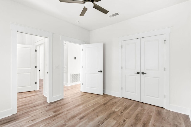 unfurnished bedroom featuring light wood finished floors, a closet, visible vents, and baseboards