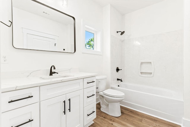 full bath featuring bathtub / shower combination, vanity, toilet, and wood finished floors