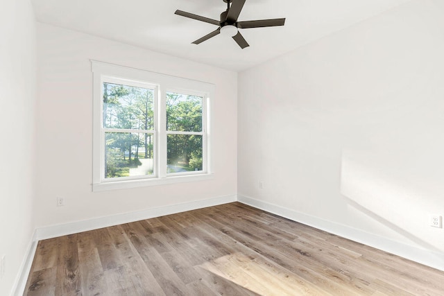 unfurnished room with ceiling fan, light wood-style flooring, and baseboards