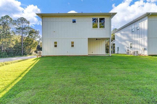 rear view of house with ceiling fan, central AC, and a lawn