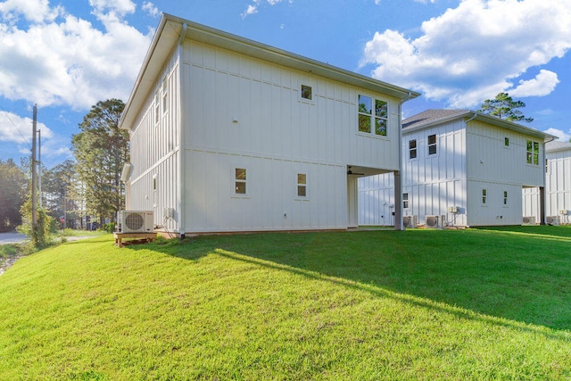 back of house featuring board and batten siding and a yard