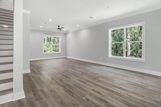 empty room with baseboards, stairway, wood finished floors, and crown molding