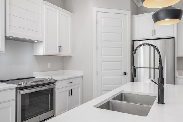 kitchen featuring light countertops, appliances with stainless steel finishes, a sink, and white cabinetry