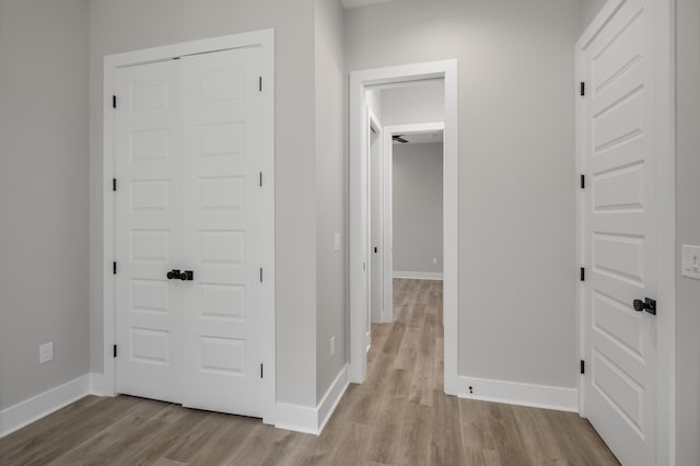 hall with light wood finished floors and baseboards