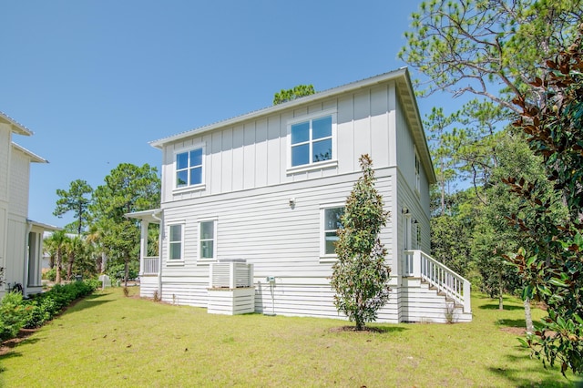 back of property featuring a yard and board and batten siding