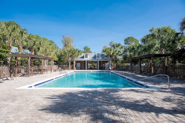 pool with a patio area, fence, and a pergola