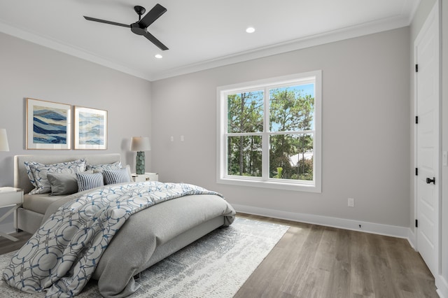 bedroom with multiple windows, ornamental molding, and wood finished floors