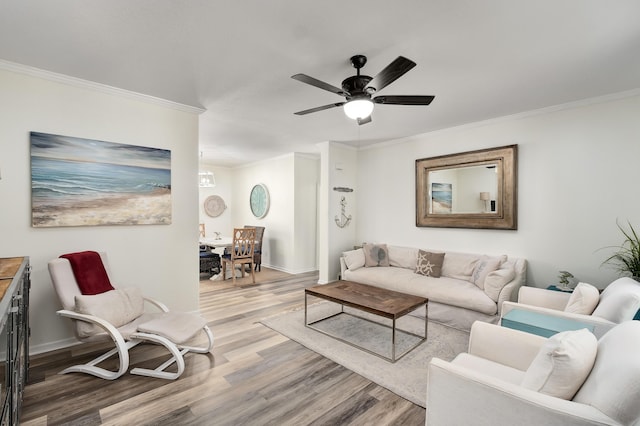 living room with hardwood / wood-style floors, crown molding, and ceiling fan