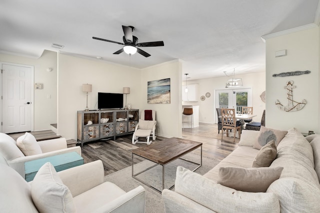 living room featuring crown molding, ceiling fan, and wood-type flooring