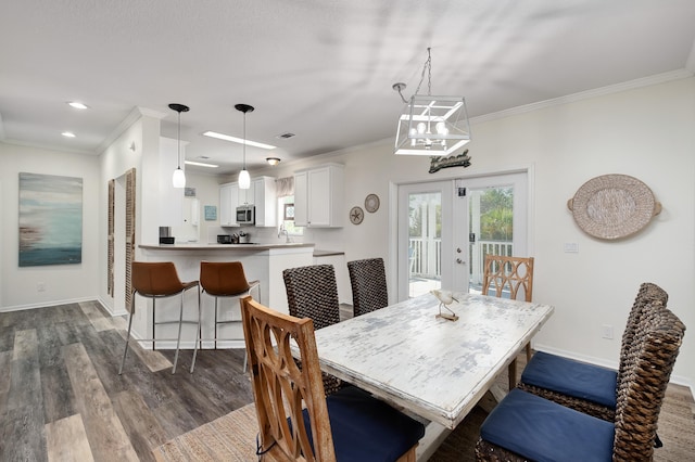 dining room featuring dark hardwood / wood-style flooring, crown molding, and french doors