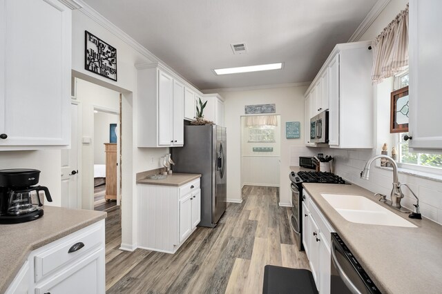 kitchen with white cabinets, stainless steel appliances, and sink